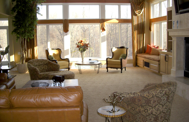 A large room overlooking a beautiful wooded back yard adapted into a comfortable space for watching television.
