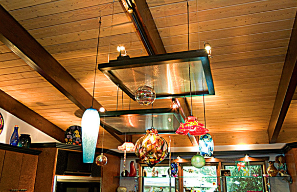 A combination of the elements, we converted the client's glass collection into a sculptural mobile suspended with lights and framed screens on the wooden ceiling.